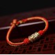 The red string is a symbol of protection, warding off negative energy, and attracting good fortune