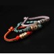 The red string is a symbol of protection, warding off negative energy, and attracting good fortune
