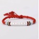 The red string protects against negative influences, while the mantra brings good luck